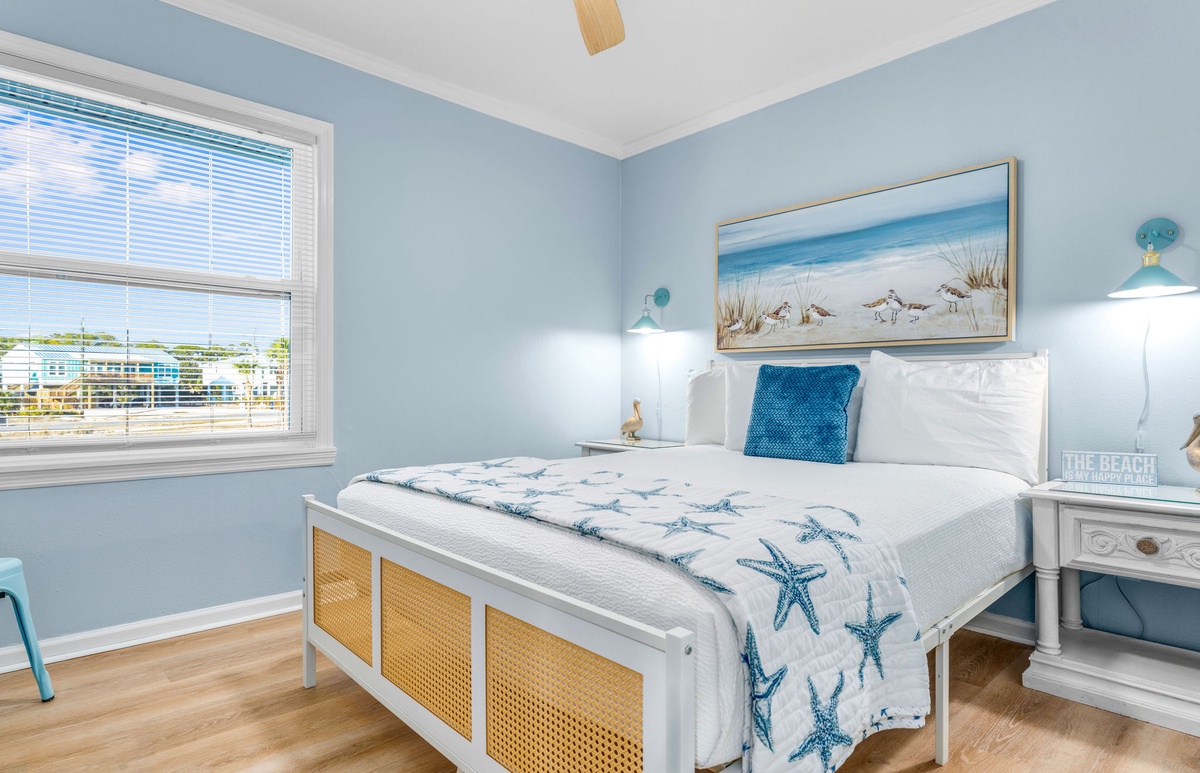 Drift into coastal dreams in your serene bedroom, where soft blue walls and starfish-printed linens create the perfect seaside sanctuary for restful nights.