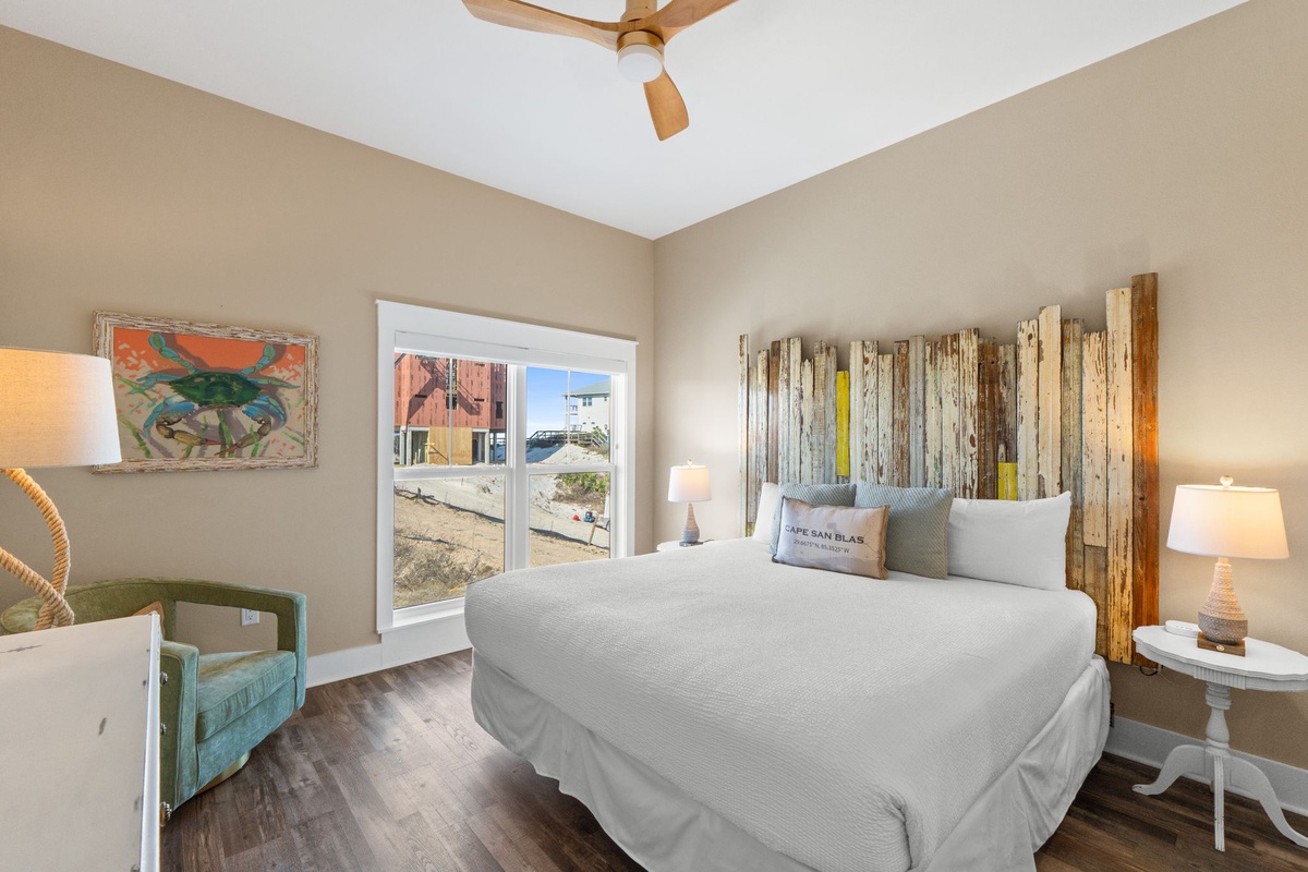 Your cozy bedroom features a rustic driftwood headboard and coastal artwork, creating the perfect seaside retreat for restful nights.