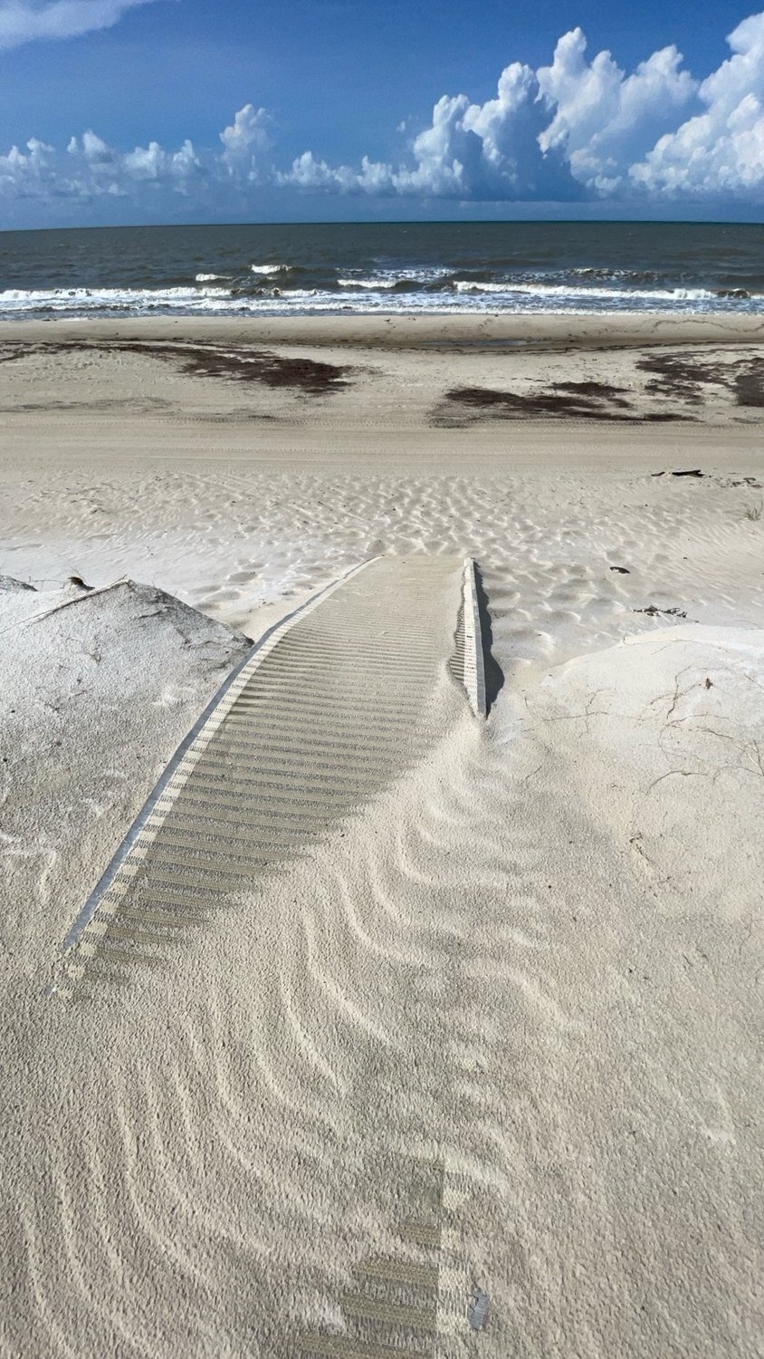 Private beach access leads to pristine sandy shores, where gentle waves meet dramatic coastal clouds along this beautiful oceanfront retreat.
