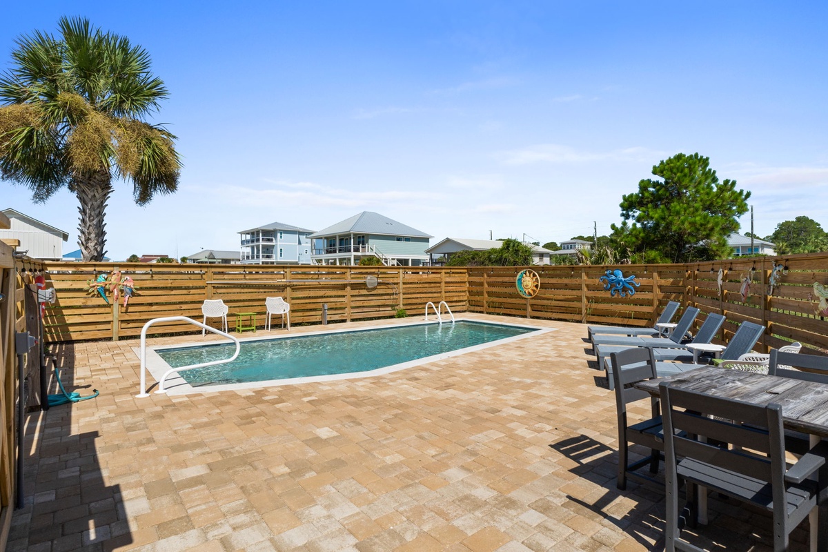 Your private pool awaits beneath sunny skies, framed by swaying palms and cushioned loungers perfect for lazy afternoons.