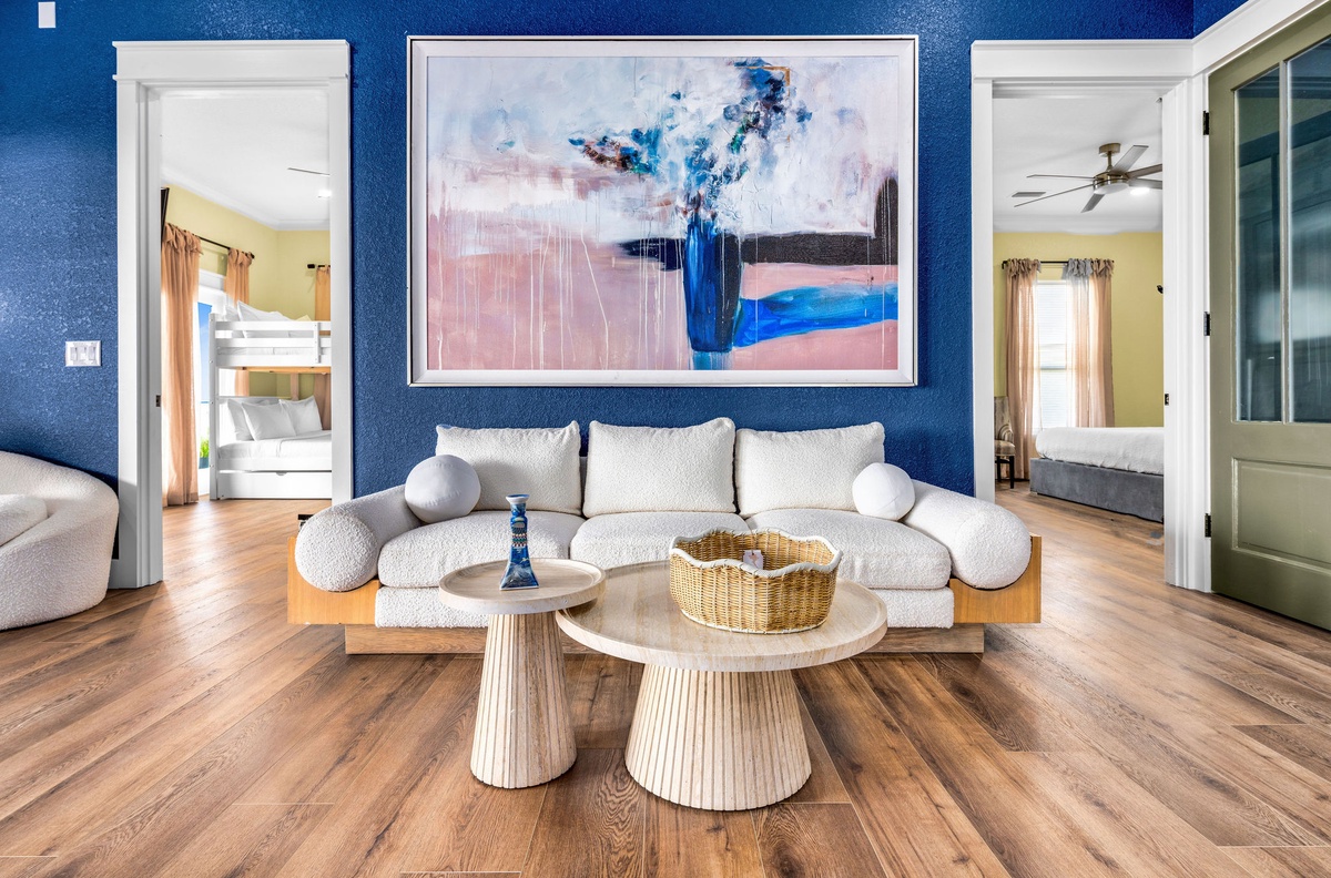 Unwind in your stylish living room featuring a plush modular sofa and stunning artwork against vibrant blue walls.