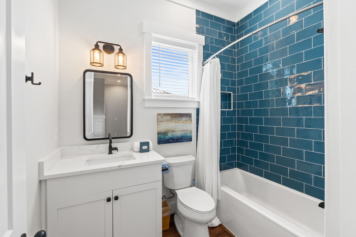 Refresh in your stylish bathroom featuring stunning teal subway tiles and modern finishes that make getting ready a joy.