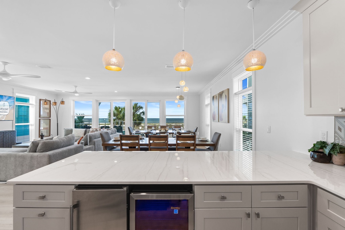 You'll love the open-concept design with stunning ocean views, sleek pendant lighting, and a spacious dining area perfect for gathering with family and friends.