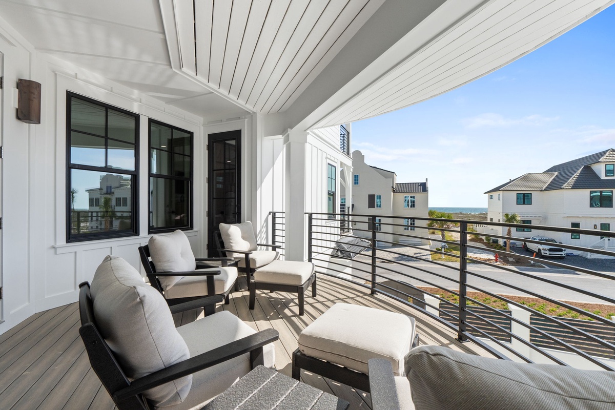 Your private balcony offers comfortable seating where you can unwind while taking in the neighborhood views and coastal glimpses beyond.