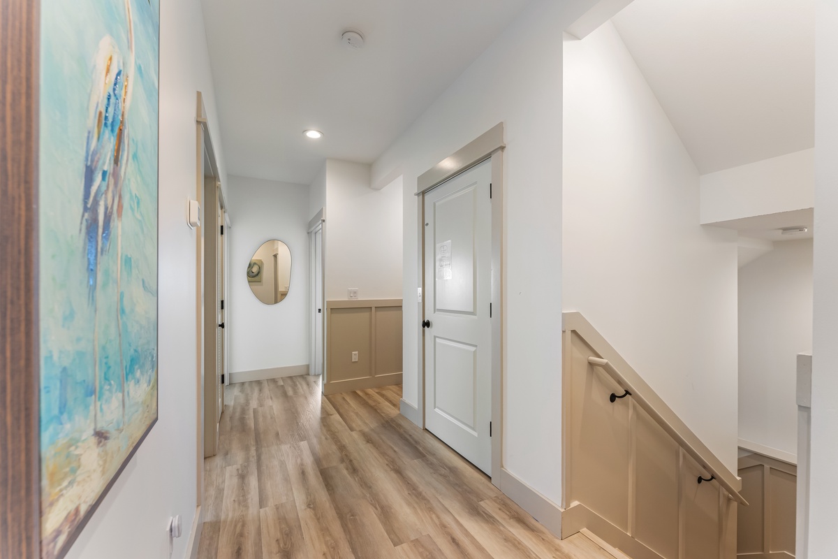 Walk through bright, airy hallways with warm hardwood floors and coastal artwork guiding you to your comfortable retreat.