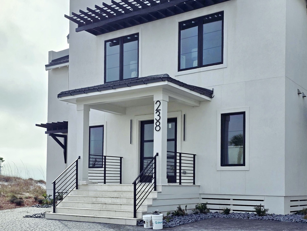 Modern two-story beach house with clean lines, covered entry porch, and contemporary design elements perfect for a coastal getaway.
