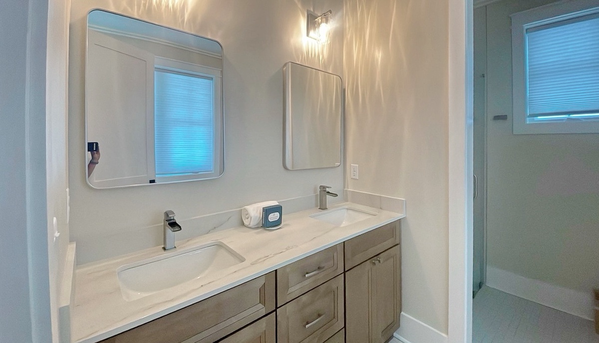 Bright, modern bathroom with dual sinks, stylish mirrors, and elegant lighting to start your mornings refreshed and ready.
