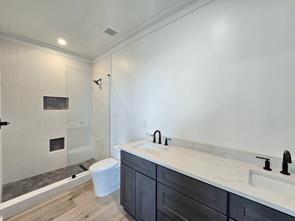 Refresh in your sleek bathroom featuring a spacious walk-in shower and elegant marble countertops for your morning routine.