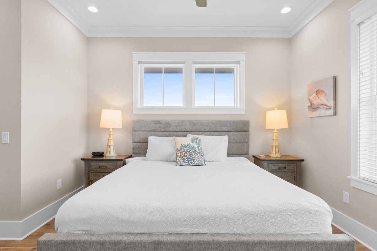 Drift off beneath soft linens and natural light streaming through your windows, with warm bedside lamps casting a gentle glow over this serene coastal retreat.