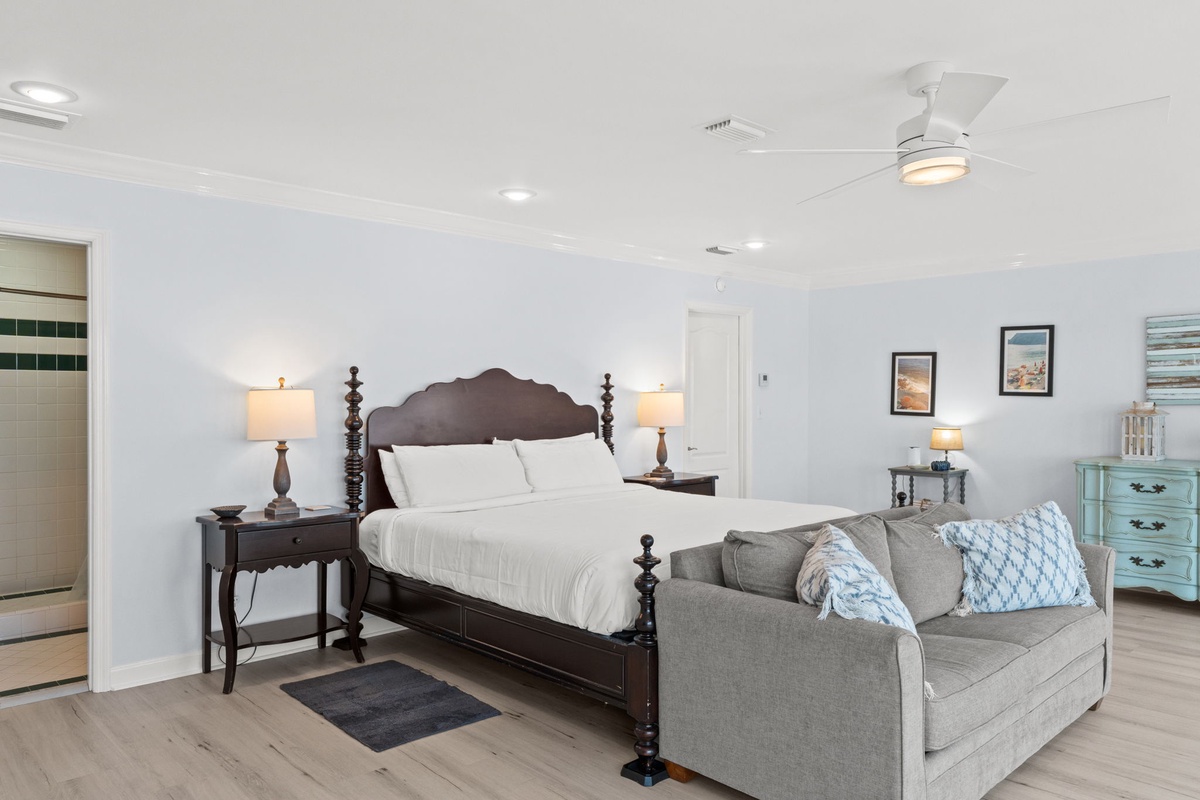 Unwind in this serene bedroom where your comfortable four-poster bed awaits alongside a cozy sofa for evening relaxation.