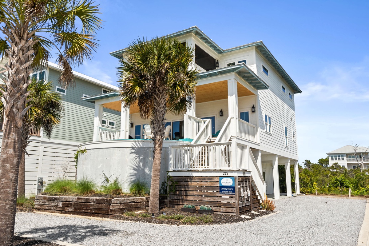 Modern coastal property featuring tropical landscaping with palm trees and stylish architecture in a peaceful residential setting.
