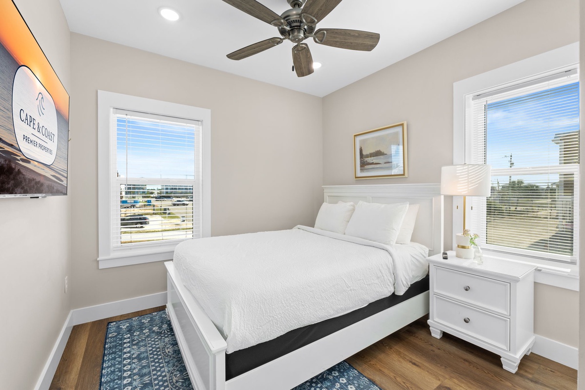 Rest peacefully in your bright bedroom with crisp white linens and city views through both windows.