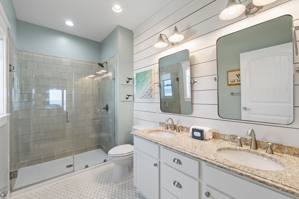 Step into your refreshing coastal bathroom, where the dual vanities and spacious walk-in shower offer the comfort you deserve after a beach day.