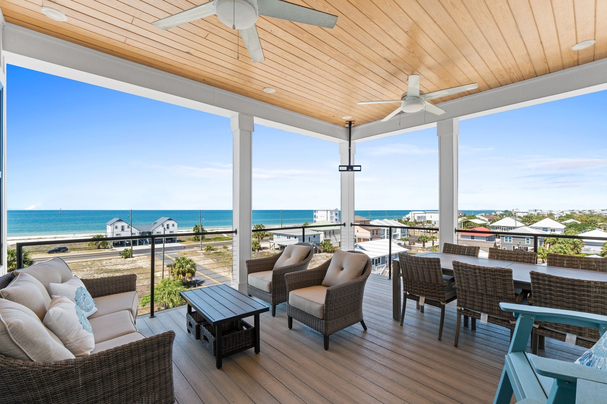 Breathe in ocean air from your covered deck with panoramic sea views, complete with ceiling fans and comfortable seating for perfect coastal relaxation.