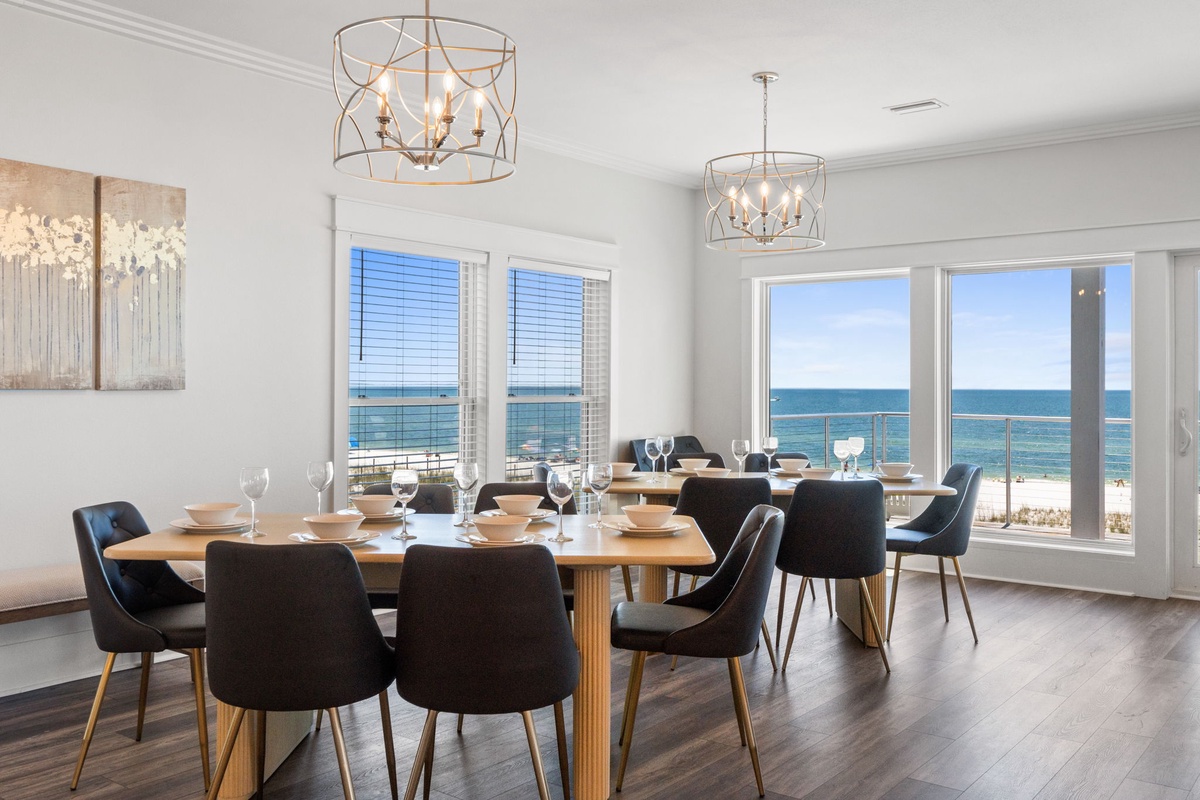 Gather around this elegant dining table where every meal becomes memorable, with stunning sea views through floor-to-ceiling windows. The modern chandeliers and coastal vistas create the perfect ambiance for your group dinners.