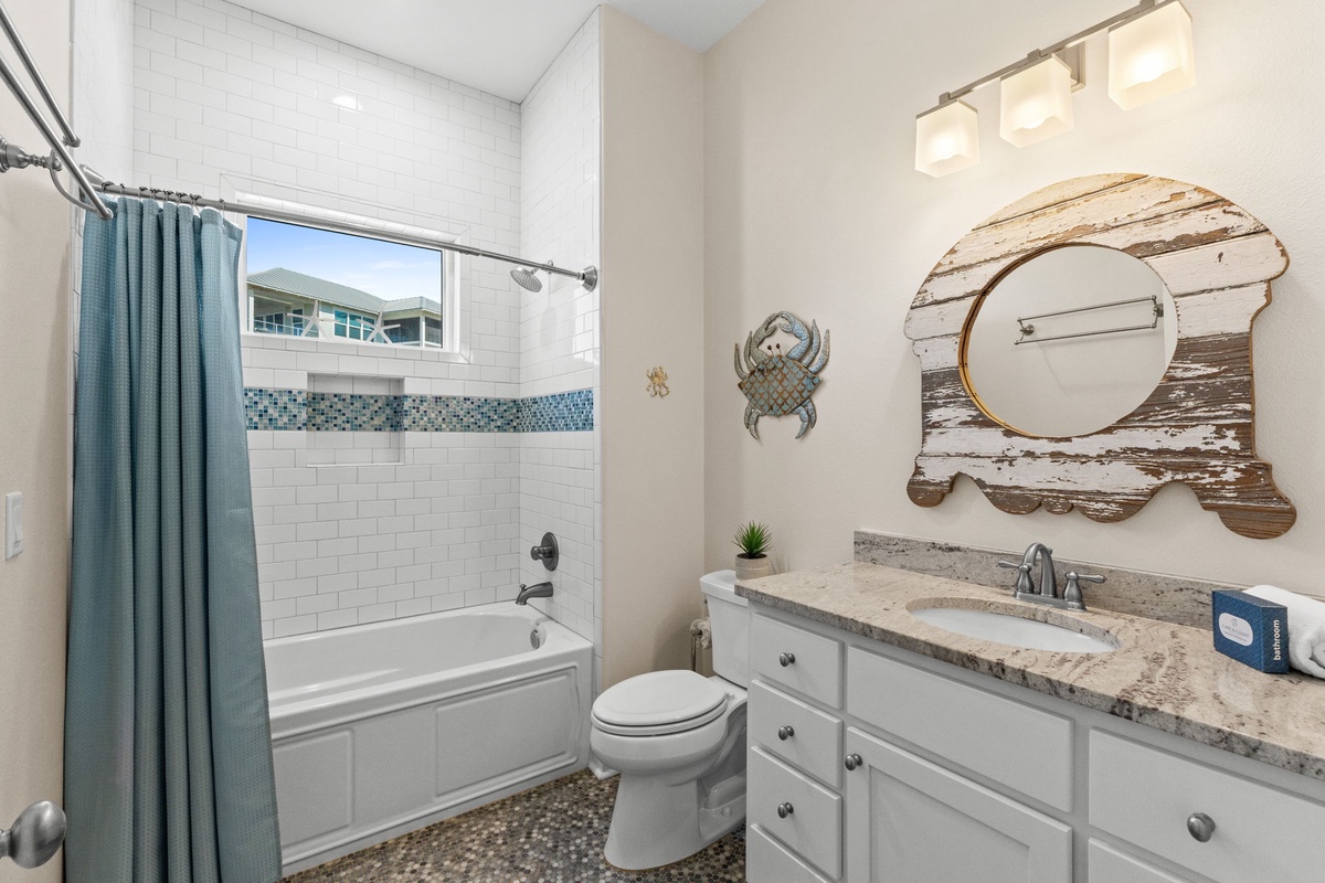 Refresh in your coastal-themed bathroom with decorative touches and a relaxing tub-shower combo.