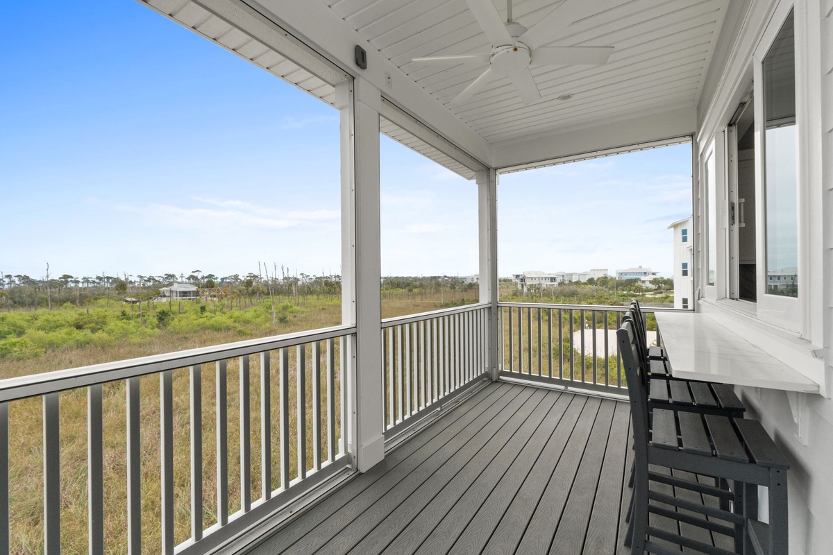 Your covered porch offers peaceful marsh views with comfortable seating for morning coffee or sunset relaxation.