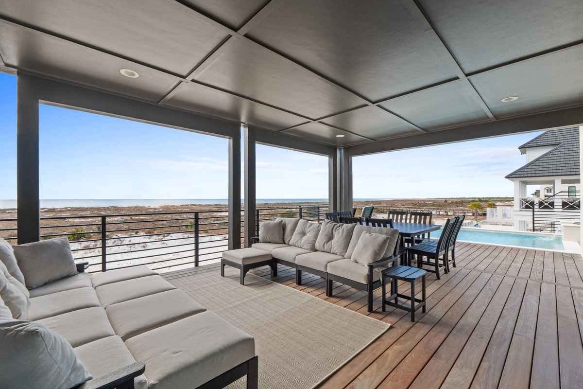 Relax under your covered terrace with stunning ocean views, complete with pool access and comfortable seating.