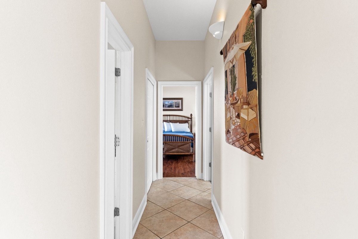 Your private hallway leads to cozy bedrooms, with tasteful artwork adorning the walls and tiled floors beneath your feet.