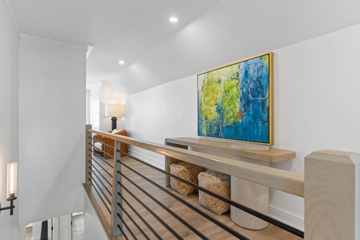 Discover your stylish upstairs landing with vibrant artwork and warm ambient lighting creating a welcoming retreat.