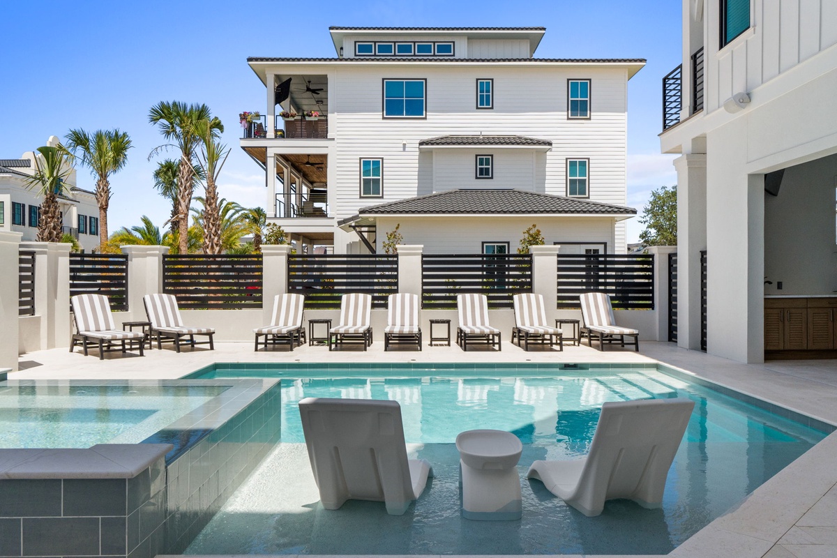 Dive into your private paradise—a stunning pool with swim-up seating, plenty of lounge chairs under swaying palms, and room to soak up the sun.