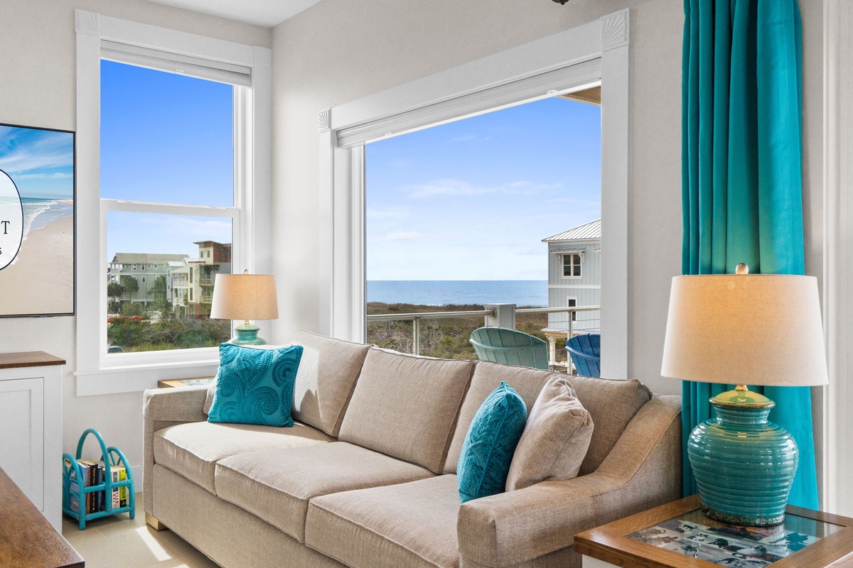 Sink into plush coastal comfort while ocean views fill your windows. Turquoise accents echo the sea beyond your private retreat.