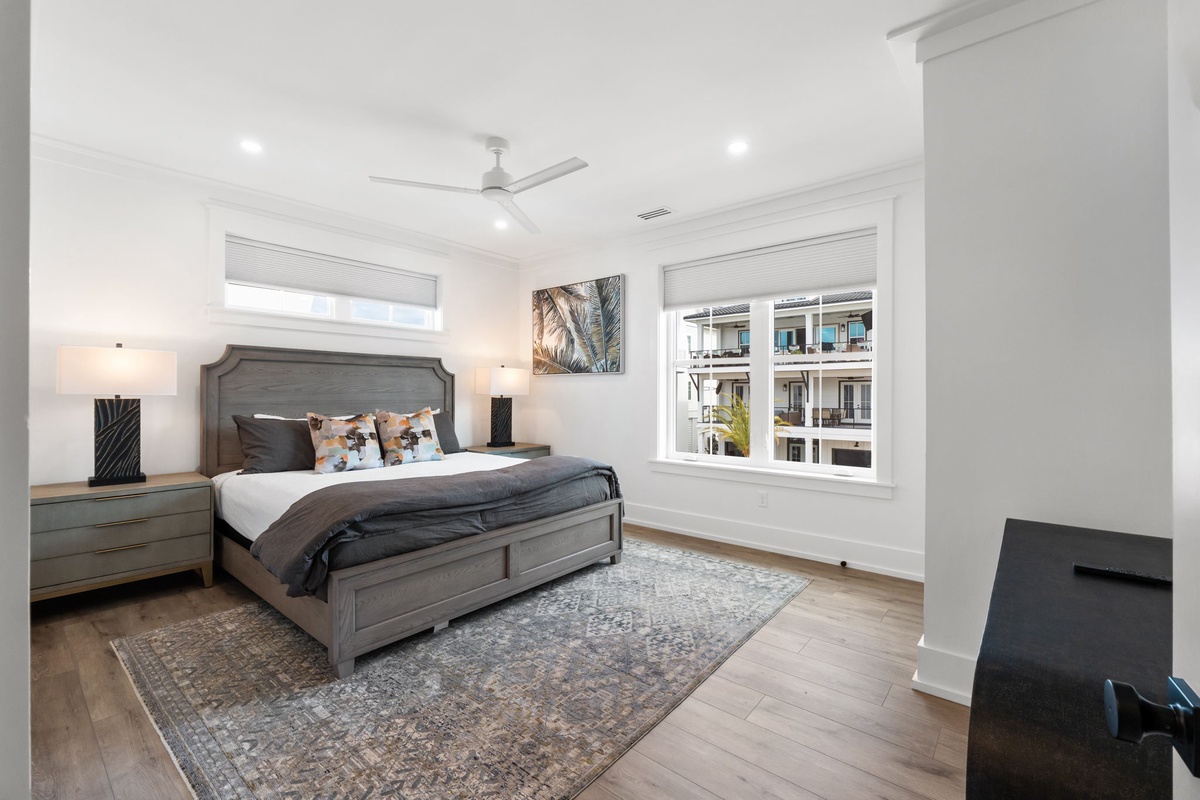Unwind in your spacious bedroom featuring a plush king bed, elegant furnishings, and natural light streaming through oversized windows for peaceful mornings.