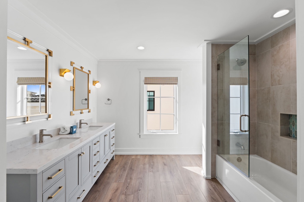 Unwind in your spacious master bathroom with dual vanities, a luxurious soaking tub, and elegant gold accents throughout.