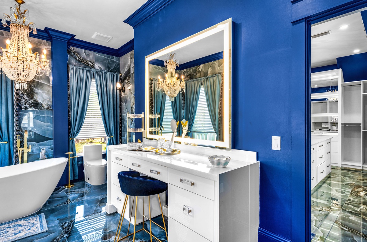Step into your luxurious royal blue bathroom oasis, complete with marble vanity, crystal chandelier, and elegant soaking tub for ultimate relaxation.