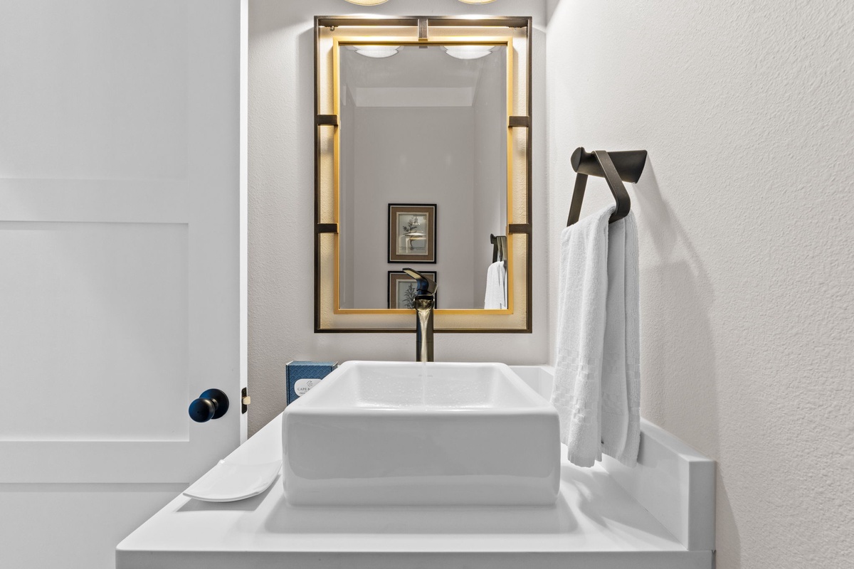 Your modern bathroom features a stylish vessel sink, elegant gold-framed mirror, and fresh towels ready for your arrival.