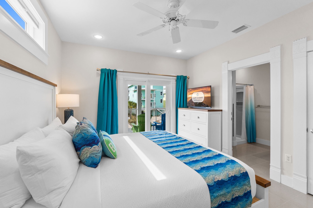 Your bright bedroom features crisp white linens with ocean-inspired accents, plus your own TV and peaceful balcony access.
