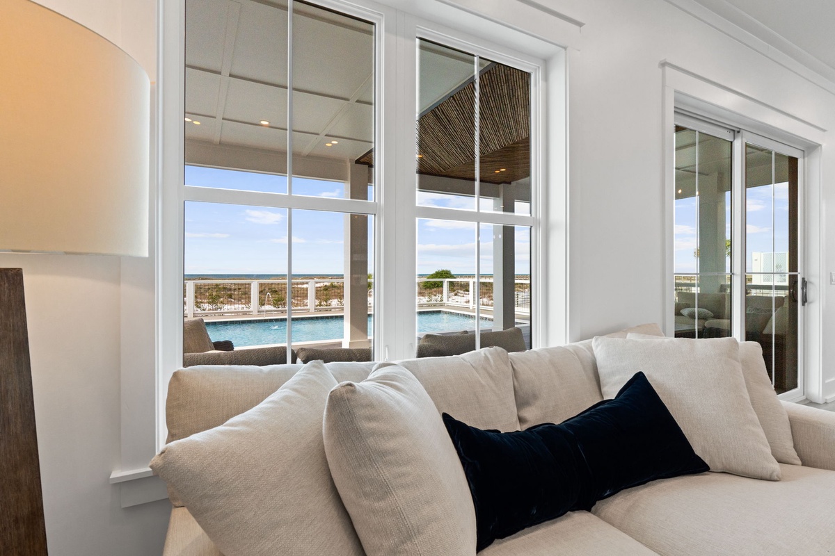 Sink into plush comfort while gazing at stunning waterfront views through expansive windows in your bright, airy living space.