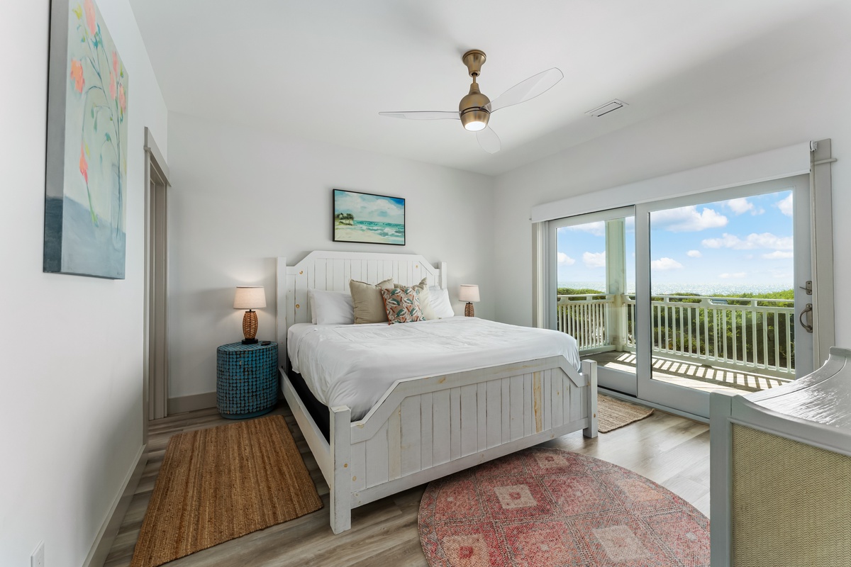 Wake up in this peaceful bedroom with your private balcony overlooking lush greenery, where coastal breezes flow through the space.