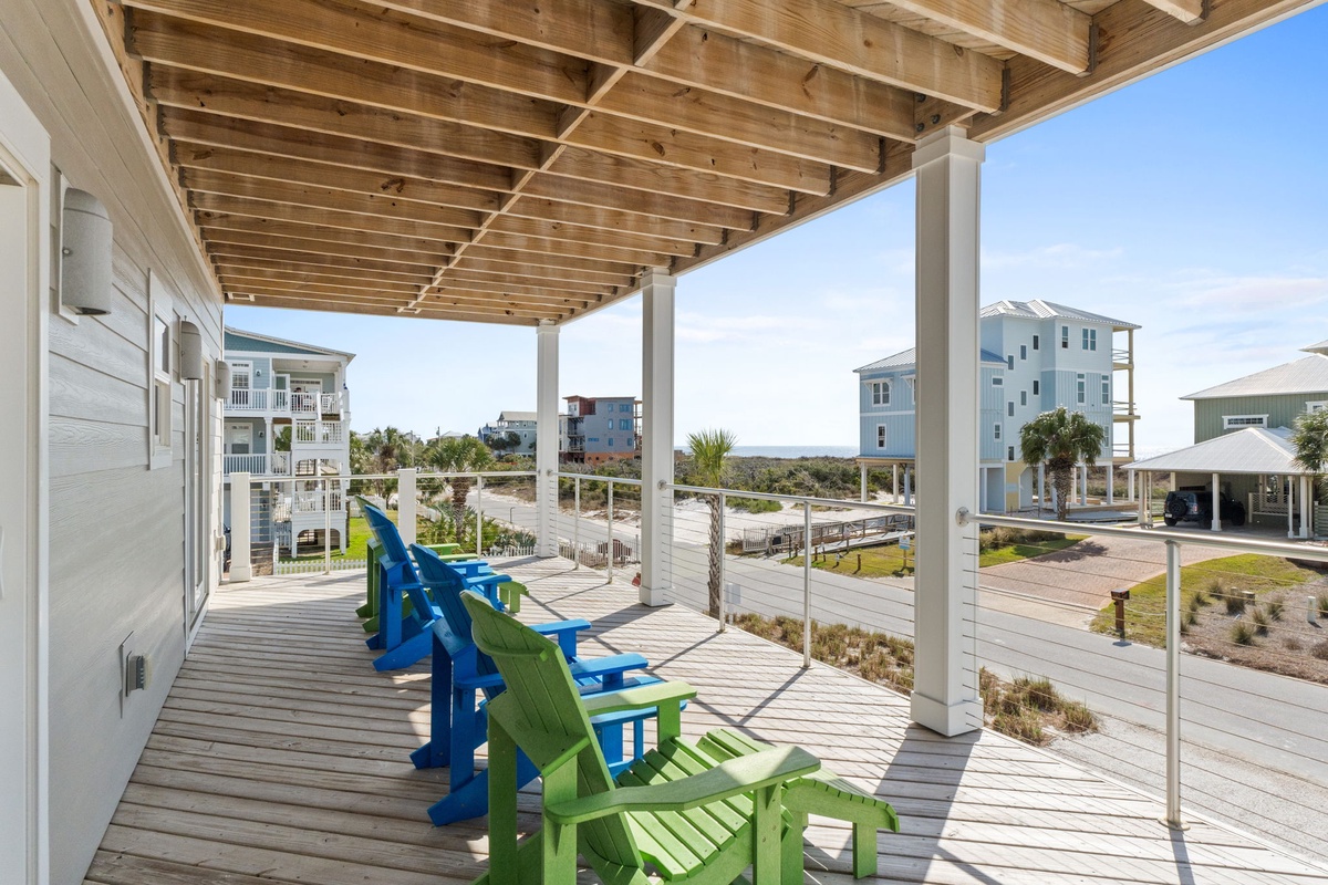 Settle into colorful Adirondack chairs on your covered deck and soak up coastal views while staying cool under the pergola.