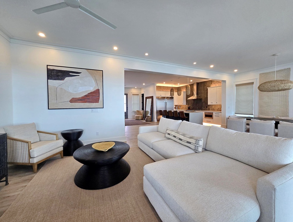 Relax in your spacious living area with plush sofas, modern art, and open-concept design flowing into the fully-equipped kitchen.