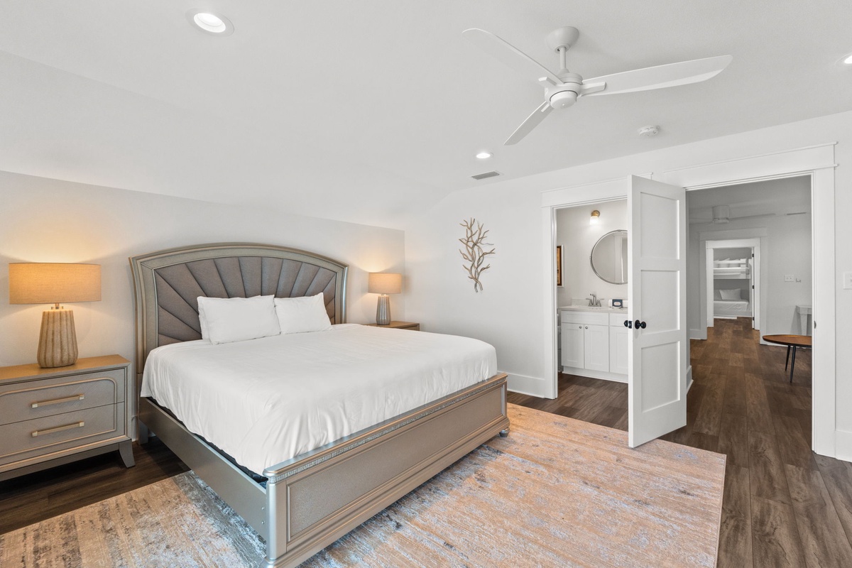 Sink into the plush bedding and let the ceiling fan create your perfect temperature. The en-suite bathroom awaits your morning routine, while elegant finishes surround you in comfort.