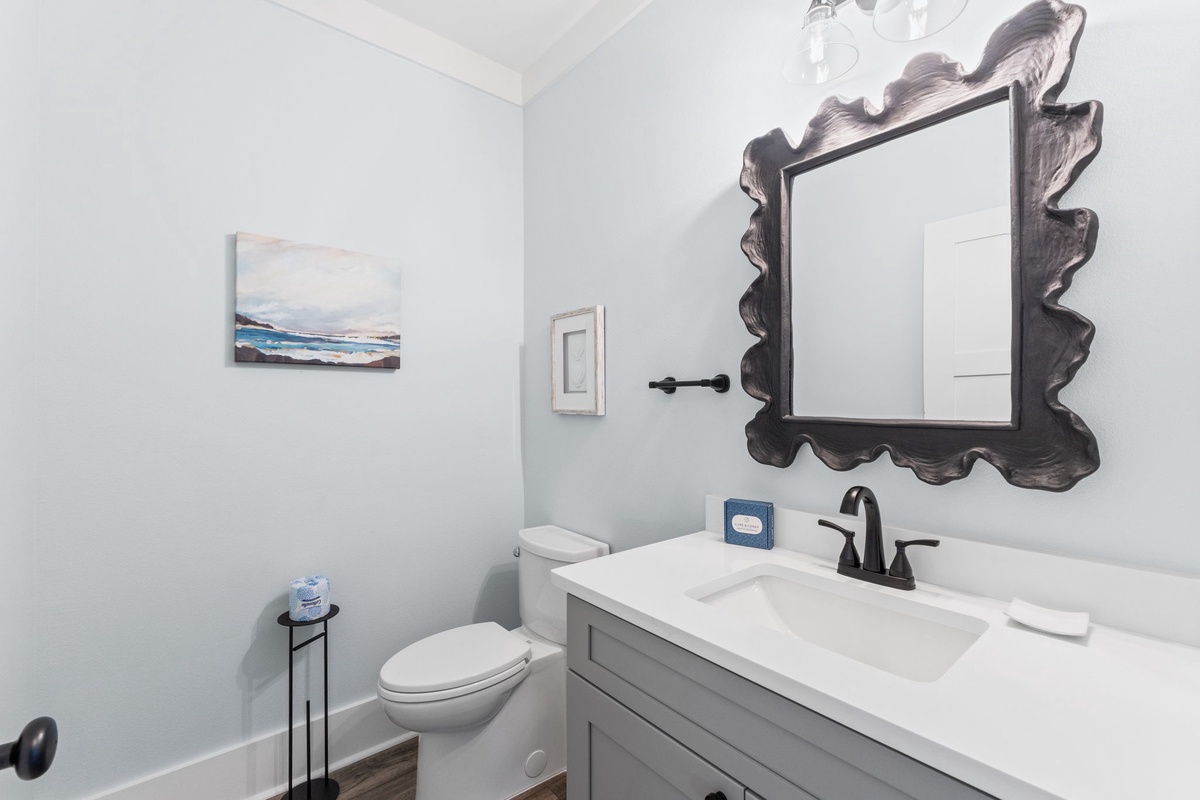 Refresh in your bright, airy bathroom with a chic vanity, a statement mirror, and coastal artwork reminding you that the beach is just moments away.