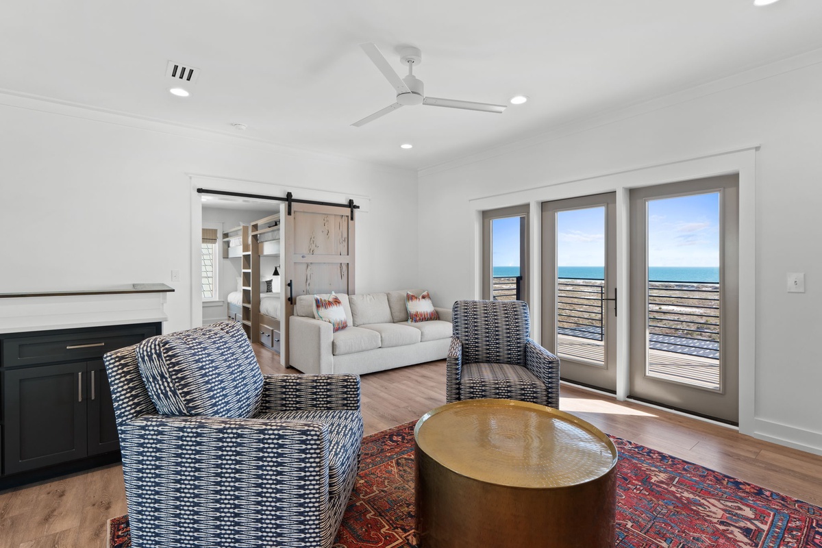 Unwind in your stylish living room with ocean views through expansive windows and comfortable seating.