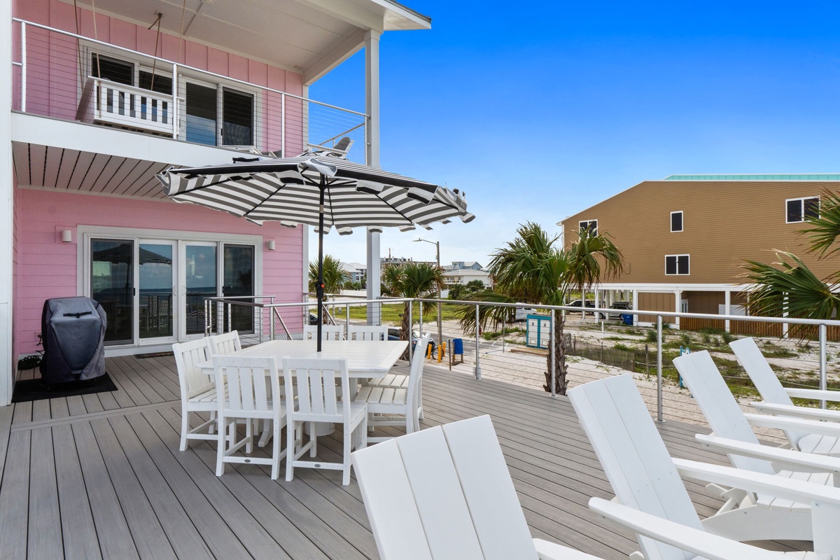 Relax on your private deck with outdoor dining and loungers under a striped umbrella. Take in clear blue skies, swaying palms, and steps to the beach. Your coastal escape awaits with a grill ready for fresh catches.