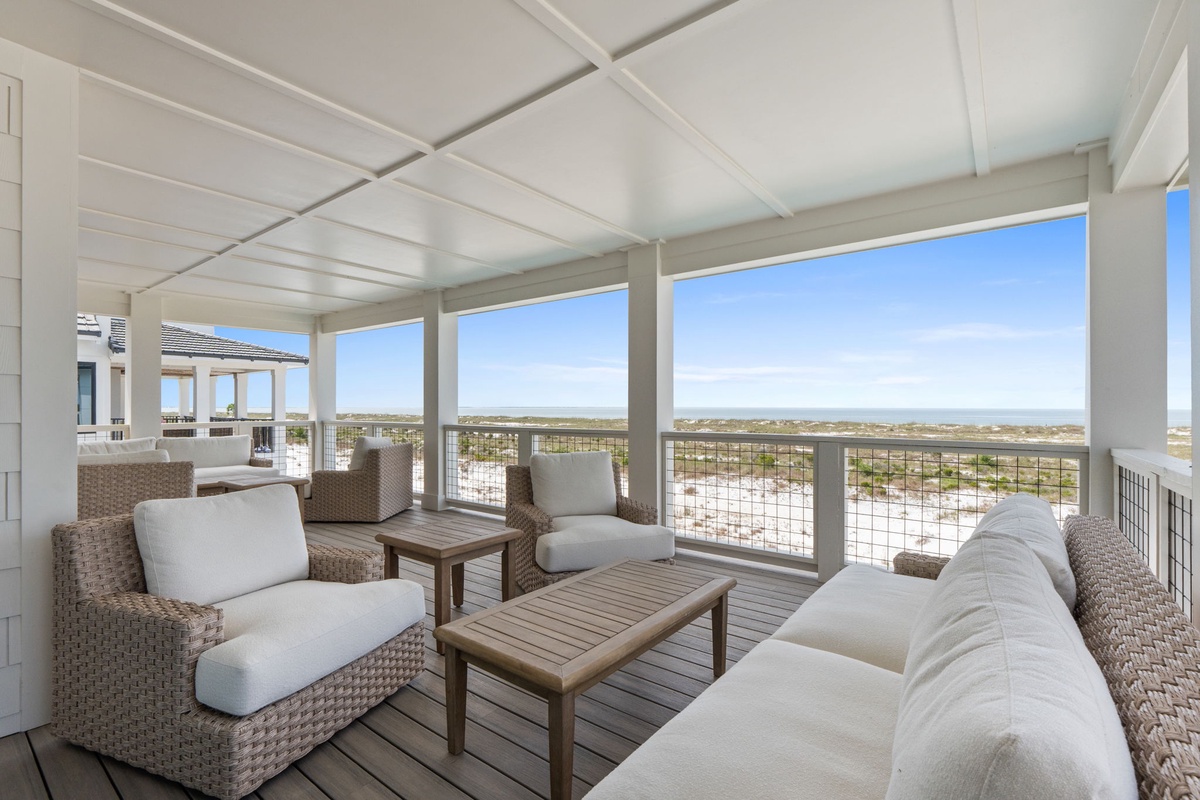 This covered terrace offers a peaceful retreat with plush seating, perfect for your morning coffee or evening relaxation while taking in the natural scenery beyond.