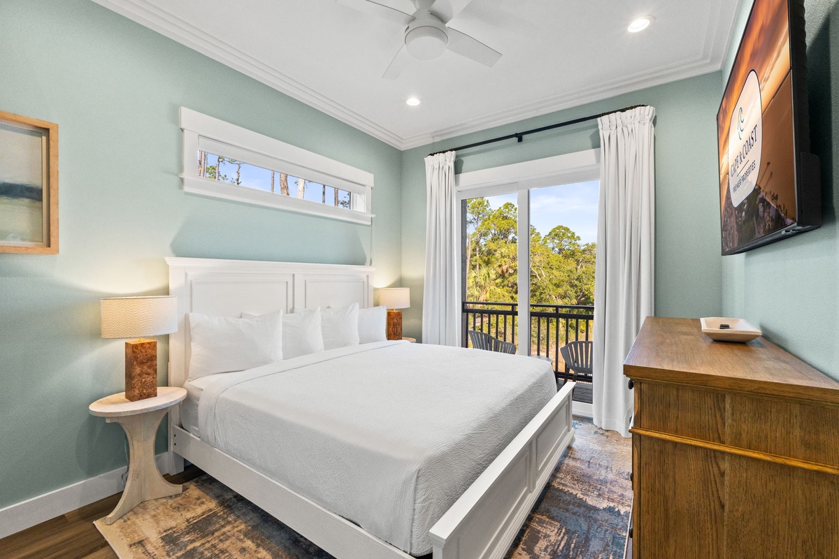 Drift off in your serene bedroom with soothing mint walls, crisp white linens, and peaceful treetop views from your private balcony.
