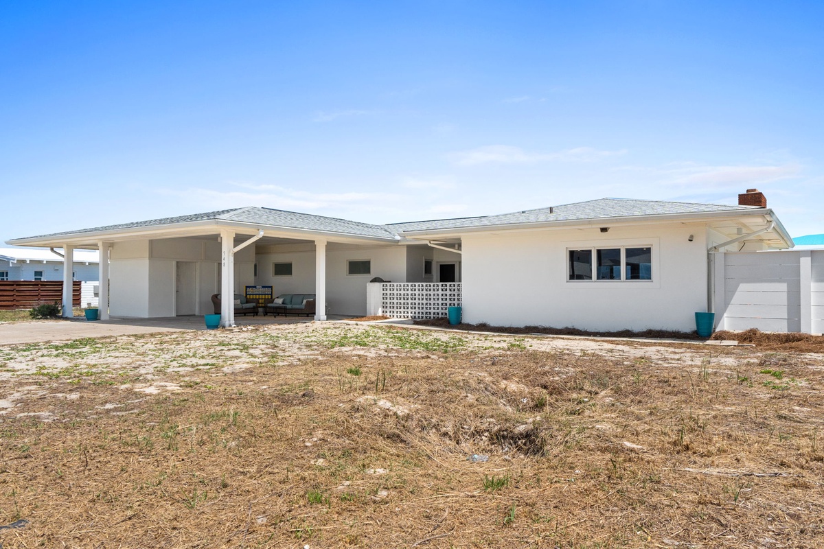 A charming beachside property with a covered patio and open layout, situated just steps from the shore in a peaceful coastal setting.