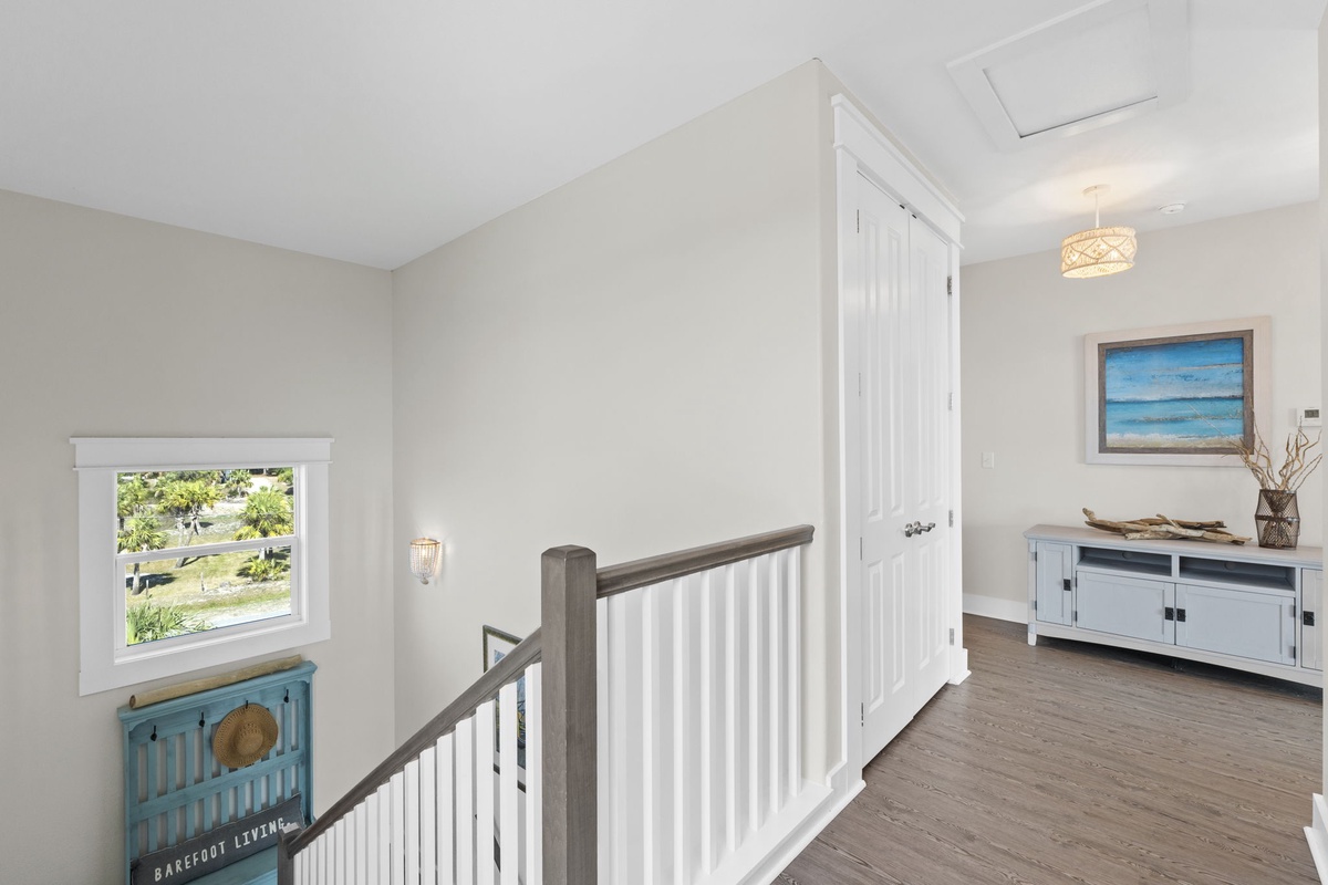 Bright, coastal-styled hallway with ocean artwork creates a serene transition between your private spaces.