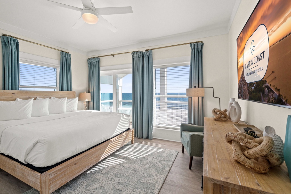 Wake up to stunning ocean views from your comfortable coastal bedroom, where soft blue curtains and crisp white linens await.