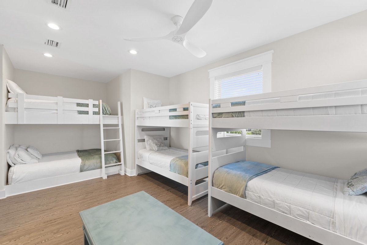 Your kids will love this bright bunk room with three comfy beds, perfect for family adventures and bedtime stories.