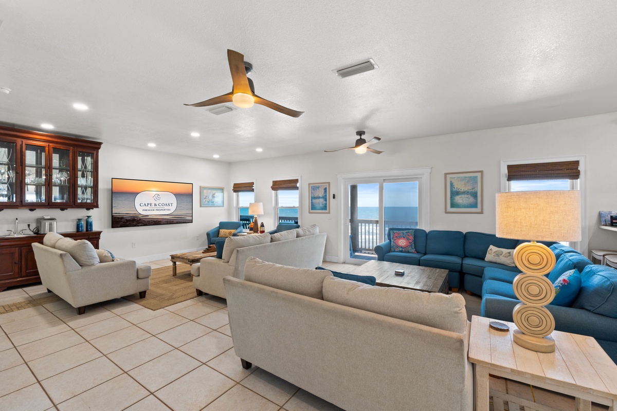 Settle into this bright, spacious living area with coastal charm, plush seating for everyone, and sweeping ocean views just beyond your private balcony.