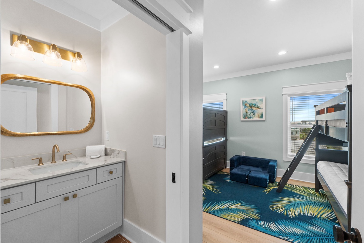 Your private bathroom with warm lighting sits steps from the bunk room, where a plush rug, fun bunk beds, and artistic touches await the kids for cozy nights.