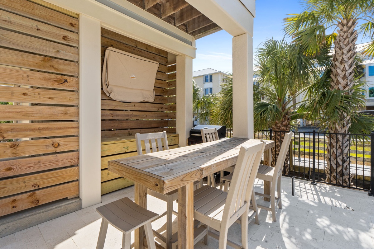 Savor your morning coffee at this charming outdoor dining area, where rustic wood meets tropical breezes and palm trees frame your perfect getaway.