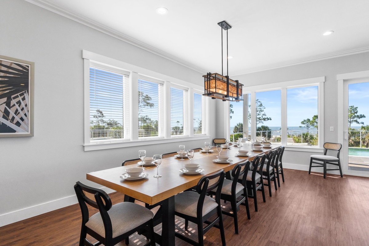 Gather around this elegant dining table where memorable meals unfold against stunning water views through floor-to-ceiling windows.