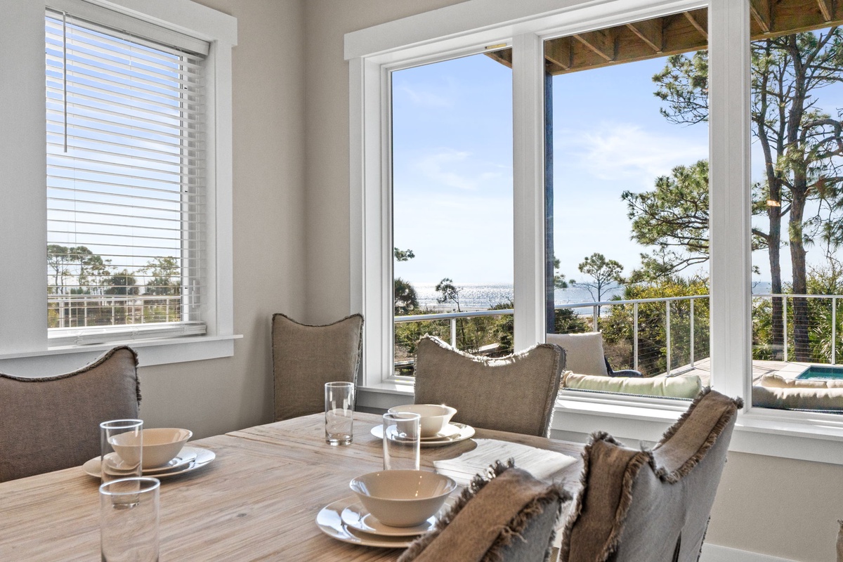 Enjoy morning coffee at your elegant dining table while gazing at stunning ocean views through expansive windows.